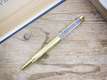 Kép 1/2 - Kék nefelejccsel díszített arany színű toll