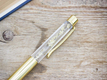 Kép 2/2 - Bodzavirággal díszített arany színű toll